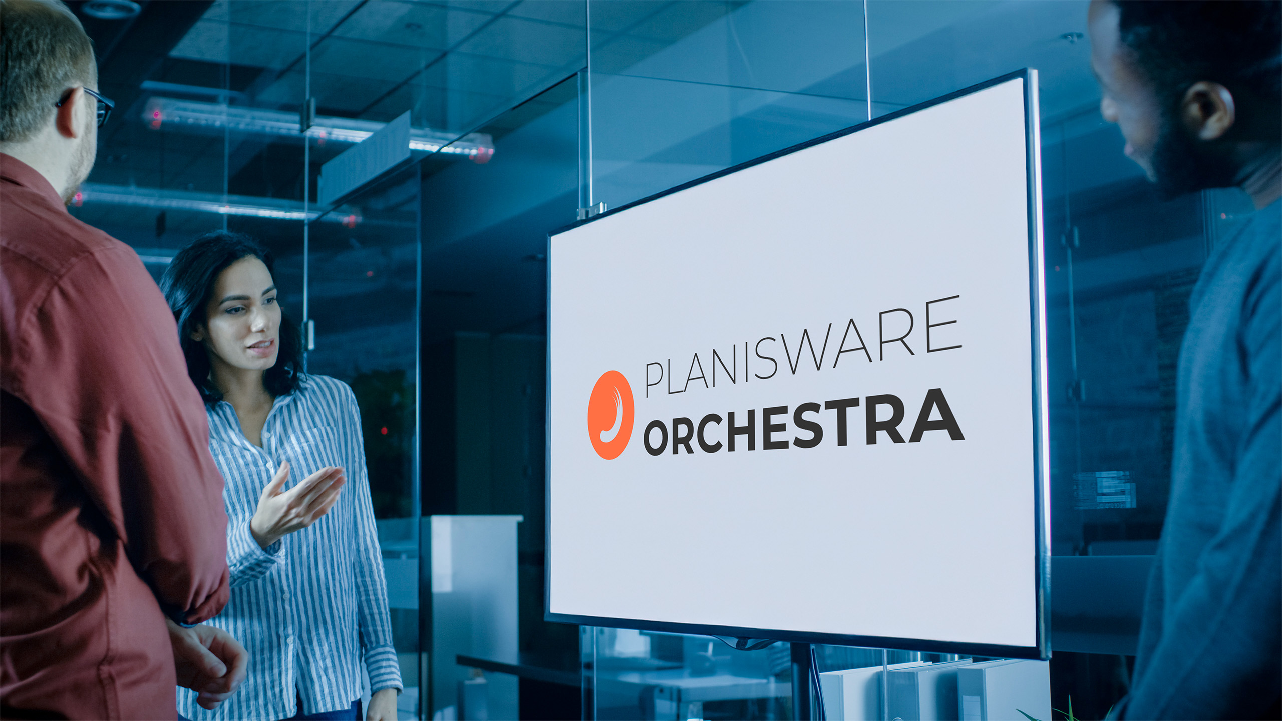 Foto eines Team Meetings im Konferenzraum, auf Bildschirm wird Logo von Planisware Orchestra angezeigt